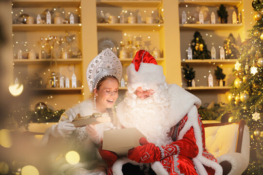 Festive gathering with ded moroz and snegurochka unwrapping gifts in cozy holiday Russia New Year setting