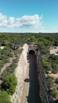 Aerial drone view in the road tunnel to Son Bou beach town. Menorca Island, Balearic islands, Spain. 