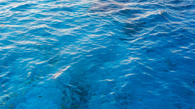 Blue abstract blue water surface with clear pool, ocean-like waves, ripples and turquoise reflections