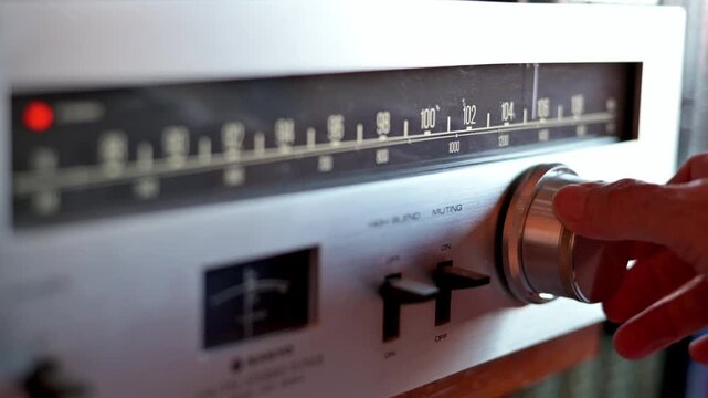 Hand Turning Knob On Vintage Analog FM Radio Tuner With Retro Dial And Controls