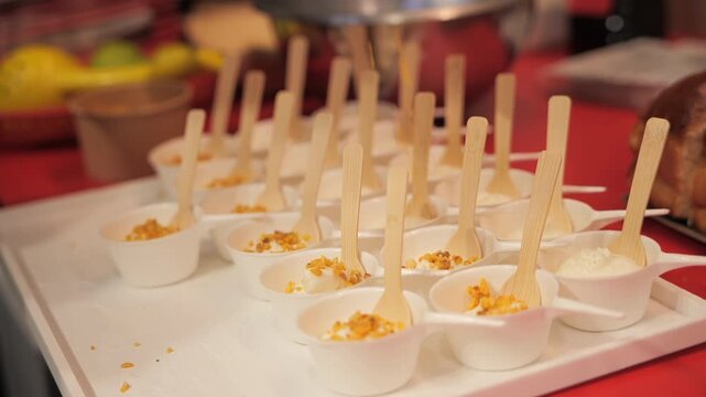 Chef&rsquo;s hands adding hazelnuts on vanilla ice cream