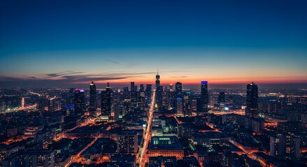 Fototapeta premium Aerial view of a vibrant cityscape at dusk with illuminated skyscrapers