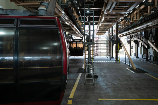 Cable car gondola terminal station. Unrecognized passengers inside gondola.