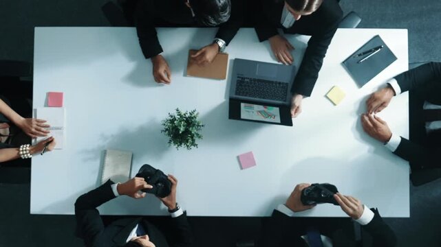 Top view of manager give vr head set to businesspeople while businesswoman prepare data analysis or financial analytic graph in laptop at meeting. Team preparing to enter meta verse. Directorate.
