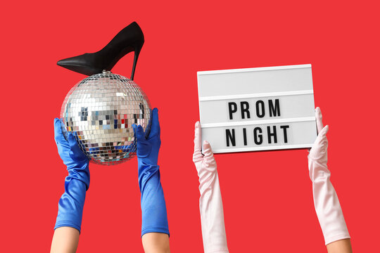 Female hands holding board with text PROM NIGHT, disco ball and high heel on red background