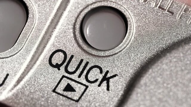 Macro view of Quick button pressed on metallic silver panel with black lettering