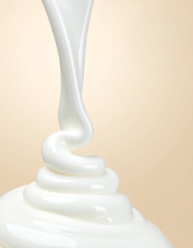 Glossy White Cream Swirl Pouring on Soft Beige Background