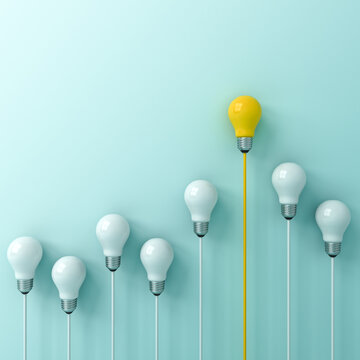 Standing out from the crowd and leadership concepts bright yellow idea bulb with the dim unlit white bulbs on light blue green pastel color background business creative idea concepts 3D rendering