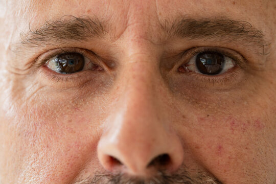 Male holding intense gaze in portrait studio, revealing window reflection and camera silhouette