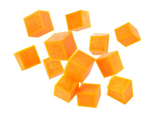 Falling pumpkin cubes isolated on white background, flying orange squash dice with motion for healthy autumn cooking and food compositing