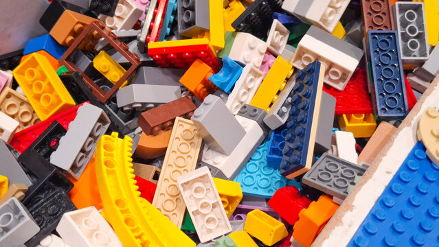 Assorted Lego plastic building blocks piled in a box for creative construction play and educational tutorial project on March 28, 2026 in Bangkok, Thailand