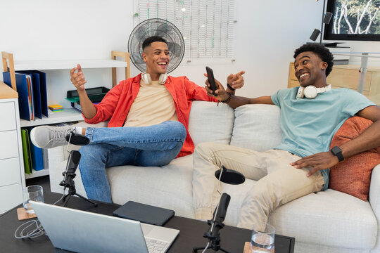 Recording diverse male friends discussing podcast topics in studio, with microphones and headphones