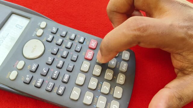 Closeup of accountant hand using scientific calculator machine for calculating business or commerce accounting cost, budget and expense. financial planning, tax calculation and finance concept.