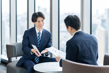 取引先に営業する若いビジネスマン　撮影協力：学校法人電波学園　東京電子専門学校 © pain au chocolat