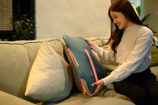 Woman setting up an ergonomic back massager cushion, highlighting comfort, wellness, and home relaxation lifestyle