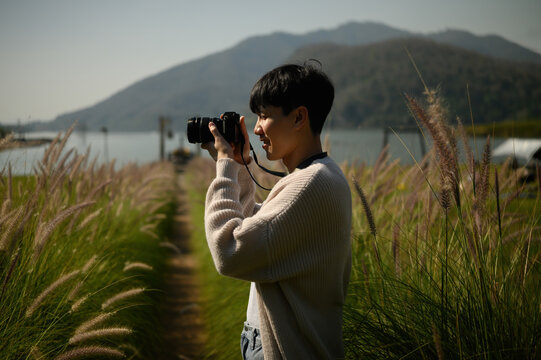 Travel and photography concept featuring a man taking pictures in a field, highlighting adventure, hobbies, and nature connection