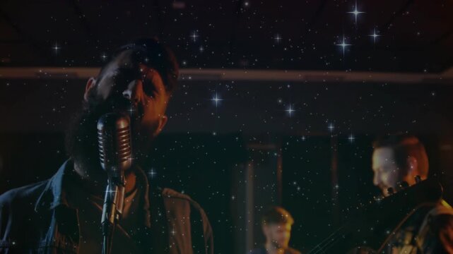 Vertical video: Singer leaning into vintage mic, driving guitar for chorus under star overlay