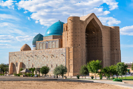Turkistan, Kazakhstan - June 2, 2025: Closeup view of the monumental Mausoleum of Khoja Ahmed Yasawi (Hoca Ahmet Yesevi T&uuml;rbesi) with its turquoise domes under a cloudy blue sky