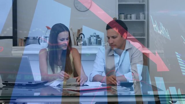 Couple managing bills in kitchen woman flipping bills sparking declining finance charts over docs