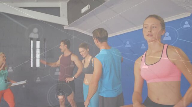 Vertical video: Pointing coach cueing woman in pink sports bra at box preparing at gym, copy space