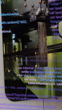 Vertical video: Filler moving bottles on rail, causing nozzle cycles to fill while code scrolling