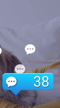 Small dog resting on bed while messaging notifications increasing, yellow-sleeve hand petting dog