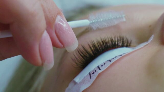 Close-up of lash artist applying extensions with precision and care for a beautiful result