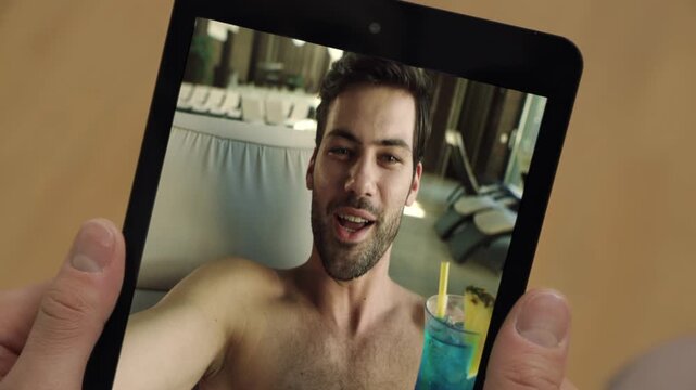 Pool guy videocall tab screen at vacation closeup. Man holding tablet computer