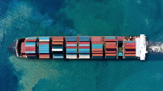 Container ship navigating global trade routes while carrying cargo through clear turquoise waters