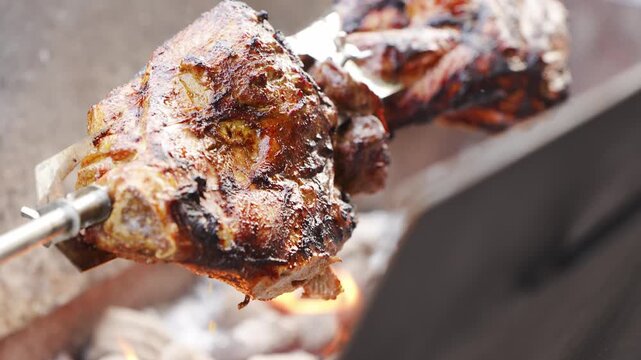 Grilling meat over open flames in a backyard cookout