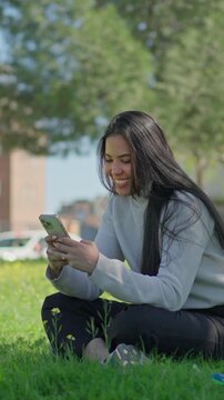 Smiling young woman looking at her smartphone and nodding her head in agreement