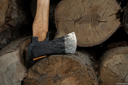 Traditional black finish Finnish axe stuck in a birch log for splitting firewood