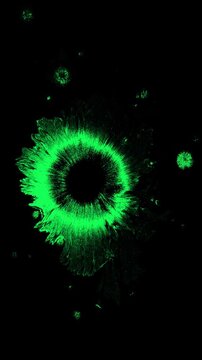 Vertical stop motion animation of a glowing green ink drop bleeding on black, for sci-fi or horror themes