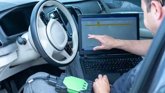 mechanic man at auto service using check up device