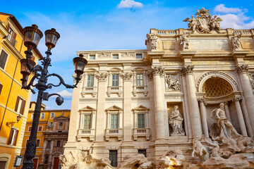 Trevi Fountain in Rome, Italy. Ancient fountain. Roman statues at piazza in old medieval city among traditional italian houses and street lamps. Famous landmark. Touristic destination for vacation.