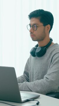 Vertical Screen : Young adult Asia male freelance eyeglasses typing write prompt AI bot app smart program nomad, video game, terminal with coding, user interface, big data center on desktop computer.