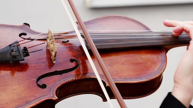 Learning to play the violin with close up shots of hands on strings and bowing technique in a practice session