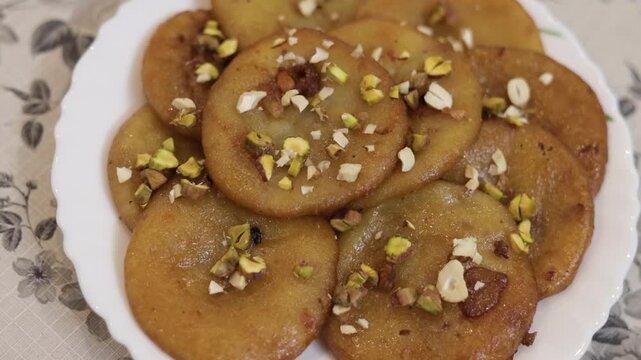 Malpua dipped in sugar syrup garnished with dry fruits