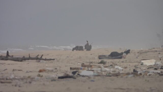An ox cart. A peasant, ryot came to the beach of the South China Sea to load sand. A picture through the haze of a midday beach. Art video