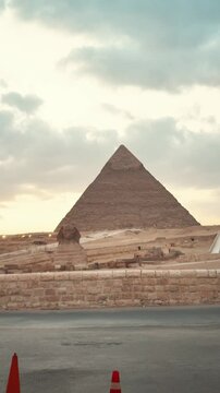 The beautiful sunset view of the great pyramid of giza and spinx at egypt on a dusk day and golden  sky in the middle of desert