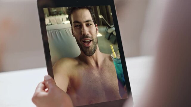 Woman hands holding videocall tab talking boyfriend online at bedroom closeup