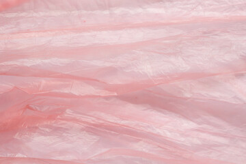 Fototapeta premium Crumpled red plastic texture, wrinkled polyethylene bag surface background