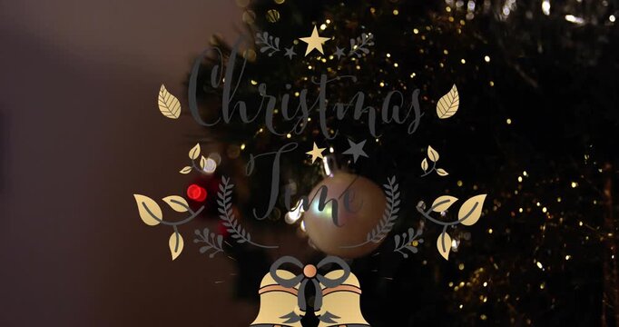Close-up of Christmas tree decorations with animated merry christmas text.