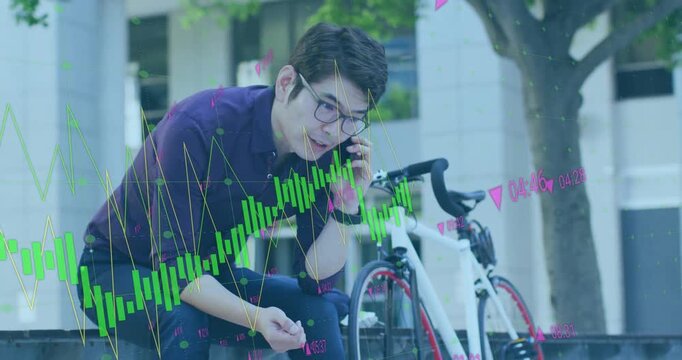 Animation of financial data processing over asian businessman talking on smartphone on city street