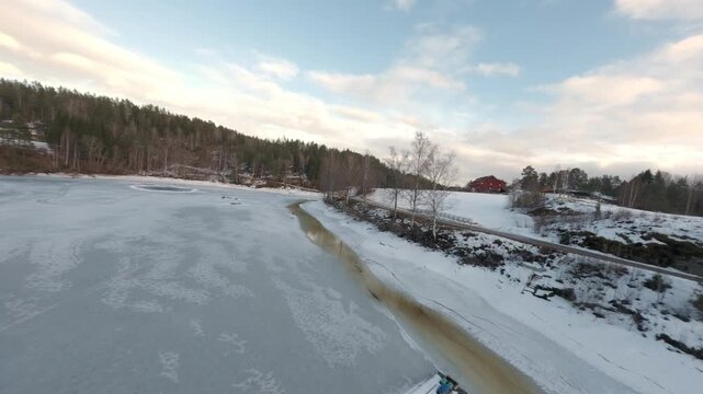 Winter FPV drone exploring frozen lake in Telemark countryside