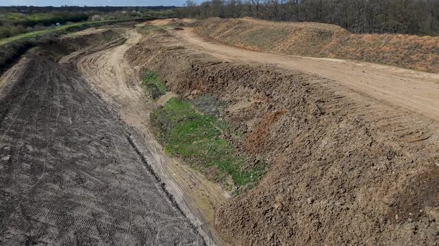 Panshanger quarry, Hertfordshire: left drone orbit and descending aerial reveals the full excavation length, terraced earthworks, haul roads, and exposed aggregate in rural England.