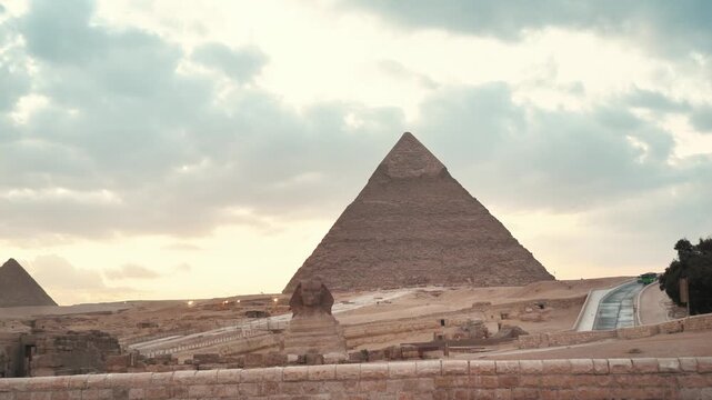 The beautiful sunset view of the great pyramid of giza and spinx at egypt on a dusk day and golden  sky in the middle of desert