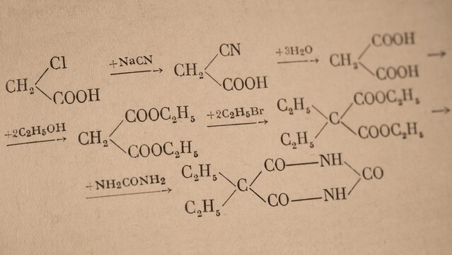 A sequence of chemical reaction equations showing the organic synthesis of barbituric acid derivatives from chloroacetic acid printed on a page of old chemistry book.