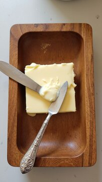 Top View of Fresh Butter in Rustic Wooden Dish with Knife