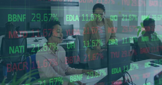 Diverse businesswomen discuss work at a desk with a computer